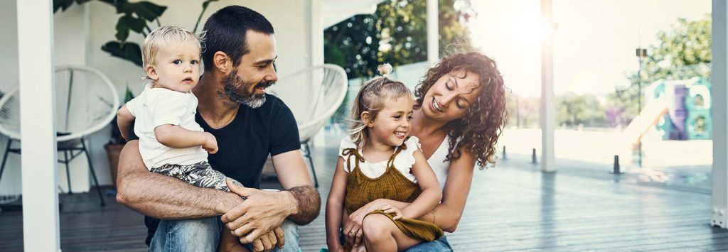 Happy family sitting out on the front porch.